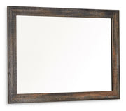 Ashley Furniture Drystan bedroom mirror with a sleek wooden frame, shown at an angle reflecting its elegant design.