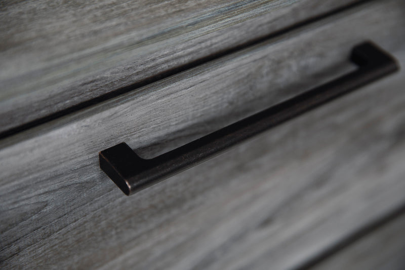 Detail view of the Ashley Furniture Baystorm Dresser showcasing its wood finish and classic drawer handles.