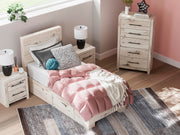 Ashley Furniture Lawroy Bed in a modern bedroom setting with neutral-toned bedding and stylish headboard design.