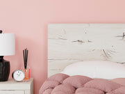 Ashley Furniture Lawroy Bed with detailed headboard in warm wood finish, showcasing elegant design and craftsmanship.