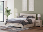Ashley Furniture Lawroy Bed with upholstered headboard and wooden frame, shown in a modern bedroom setting.