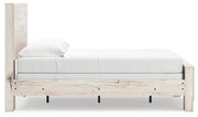 Ashley Furniture Lawroy Bed with wooden frame and headboard, shown from the side in a well-lit bedroom setting