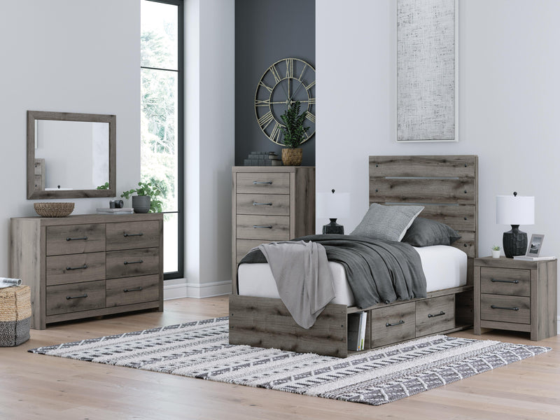Graystorm storage bed by Ashley Furniture featuring a gray upholstered frame with built-in storage drawers.