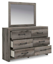 Graystorm Bedroom Set by Ashley Furniture, featuring a bed, nightstands, and dresser in a modern gray finish, shown from an angled view