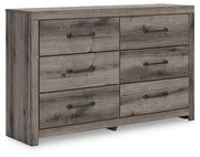 Graystorm dresser by Ashley Furniture featuring a modern gray finish and sleek drawer handles, shown from an angled side view.