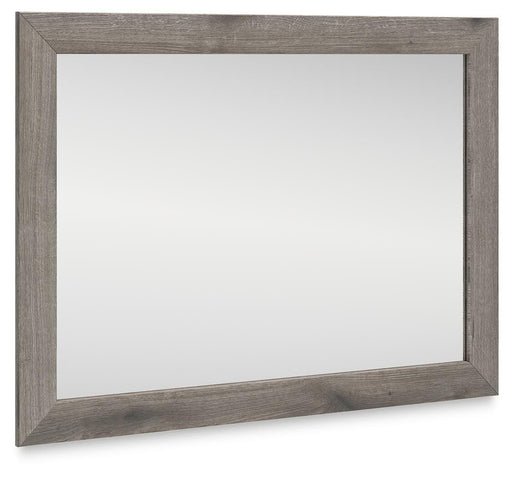 Graystorm bedroom mirror by Ashley Furniture, angled view showing a sleek, modern mirror with a gray finish.