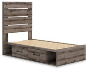 Graystorm Bed with Storage by Ashley Furniture, angled view showing gray upholstered bed frame with built-in storage drawers.