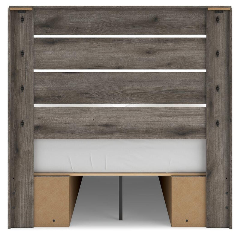 Graystorm storage bed by Ashley Furniture with a padded headboard and built-in drawers, shown from the back view.