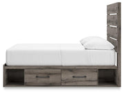 Graystorm storage bed by Ashley Furniture with a modern gray upholstered headboard and built-in storage drawers underneath.