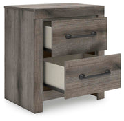 Graystorm bedroom set by Ashley Furniture, including bed frame, dresser, and nightstands, shown from an angled open view.