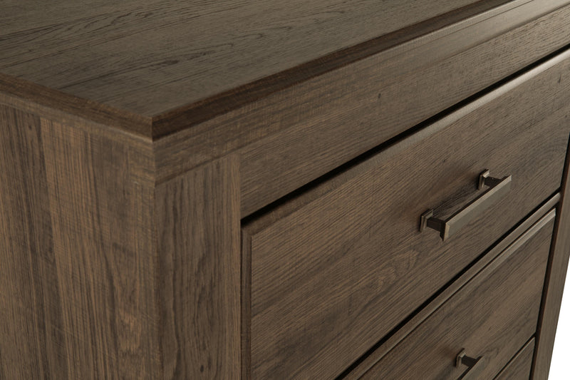 Detailed view of Ashley Furniture Juararo chest of drawers showcasing its elegant wood finish and classic design.