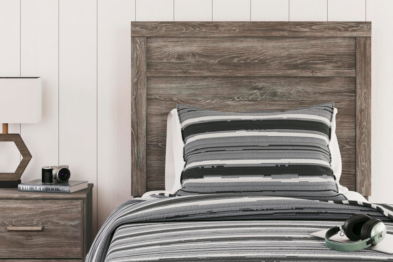Close-up of the Ashley Furniture Ralinksi Bedroom Set showing detailed wood finish and elegant bed frame design.