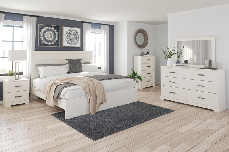 Ashley Furniture Stelsie Bed with a wooden frame and plush fabric upholstery, shown in a cozy bedroom setting.