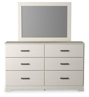 Ashley Furniture Stelsie bedroom set with a headboard, dresser, and nightstands in a modern, stylish bedroom arrangement.