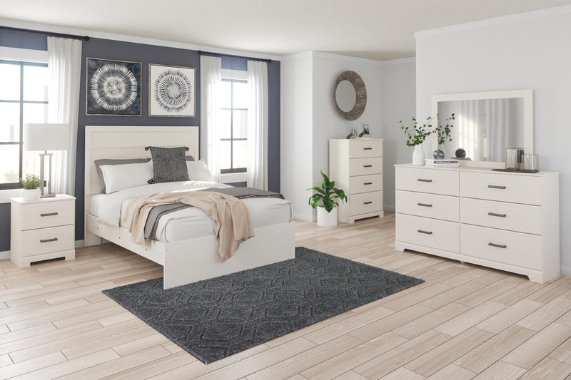 Ashley Furniture Stelsie Bed with upholstered headboard and sleek wooden frame, shown in a modern bedroom setting.
