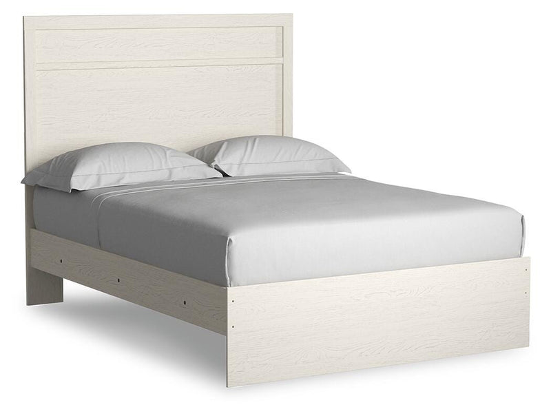 Ashley Furniture Stelsie bedroom set with a bed, dresser, and nightstands, shown from an angled view in a cozy bedroom setting.