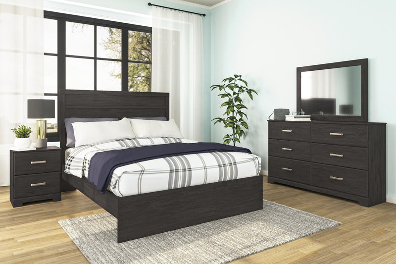 Ashley Furniture Belachime Bed with a wooden frame and elegant headboard design, shown in a cozy bedroom setting.