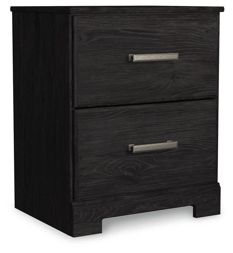 Ashley Furniture Belachime nightstand with a closed drawer and wood finish, shown from an angled side view in a bedroom setting.