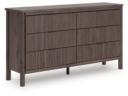 Ashley Furniture Pamytta dresser with multiple drawers, light wood finish, and modern design, shown from an angled side view.