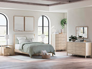 Ashley Furniture Cadmori upholstered bed with a padded headboard and neutral fabric, shown in a modern bedroom setting.