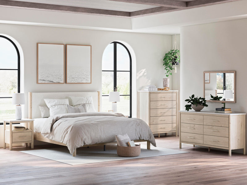Ashley Furniture Cadmori upholstered bed with a tufted headboard and neutral fabric, shown in a modern bedroom setting.