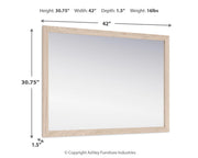 Ashley Furniture Cadmori bedroom mirror with a sleek, modern design and wooden frame, shown hanging on a bedroom wall.