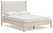 Ashley Furniture Cadmori upholstered bed with plush fabric and sleek design, shown from an angled side view.