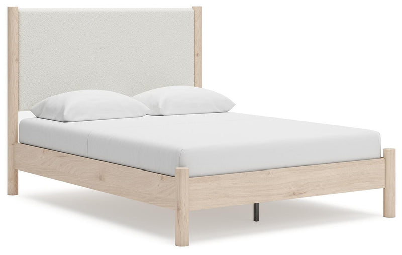 Ashley Furniture Cadmori upholstered bed with plush fabric and sleek design, shown from an angled side view.