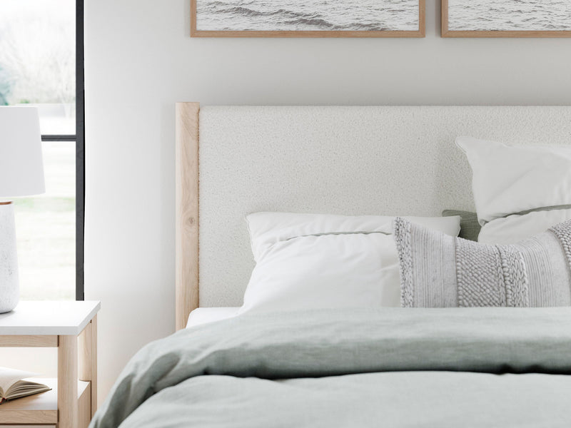 Ashley Furniture Cadmori upholstered bed with tufted headboard and neutral fabric, showcasing detailed fabric and elegant design.