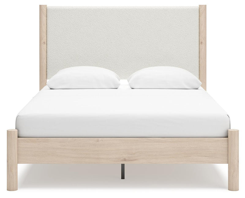 Ashley Furniture Cadmori upholstered bed with padded headboard and neutral fabric, shown from a front head-on view.