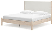 Ashley Furniture Cadmori upholstered bed with plush headboard and sleek frame, shown from an angled side view.