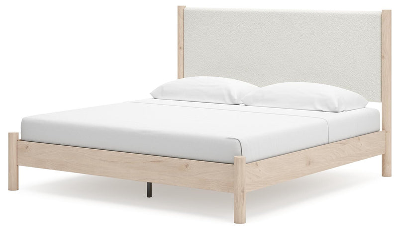 Ashley Furniture Cadmori upholstered bed with plush headboard and sleek frame, shown from an angled side view.