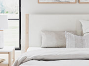 Ashley Furniture Cadmori upholstered bed with detailed fabric headboard in a modern bedroom setting.