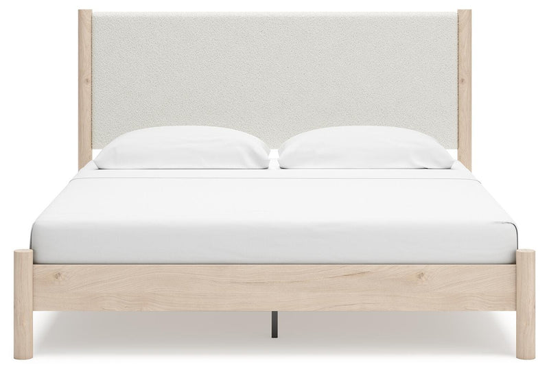 Ashley Furniture Cadmori upholstered bed with a plush headboard and neutral fabric, shown from a front head-on view.