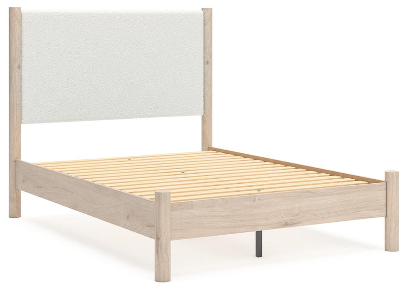 Ashley Furniture Cadmori upholstered bed with a stylish headboard and neutral fabric, shown from an angled side view.