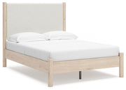 Ashley Furniture Cadmori upholstered bed with a modern design, featuring a padded headboard and neutral fabric upholstery.