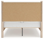 Ashley Furniture Cadmori upholstered bed with a padded headboard and neutral fabric, shown from the back in a modern bedroom setting.