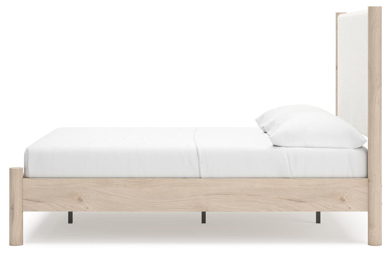 Ashley Furniture Cadmori upholstered bed with beige fabric and tufted headboard, shown from a side angle.