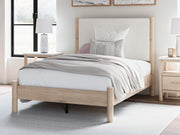 Ashley Furniture Cadmori upholstered bed with plush fabric and a stylish headboard, shown in a modern bedroom setting.