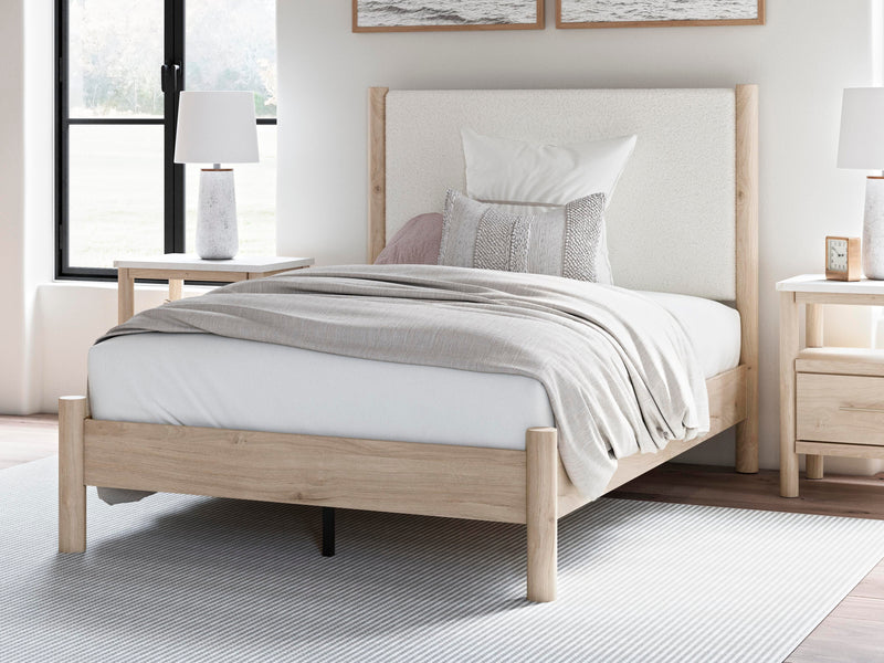 Ashley Furniture Cadmori upholstered bed with plush fabric and a stylish headboard, shown in a modern bedroom setting.