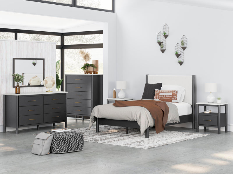 Ashley Furniture Cadmori upholstered bed with a padded headboard and neutral fabric, shown in a stylish bedroom setting.