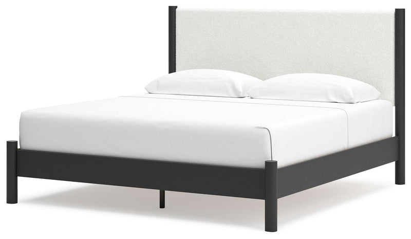 Ashley Furniture Cadmori upholstered bed with a padded headboard and elegant design, shown from an angled side view.