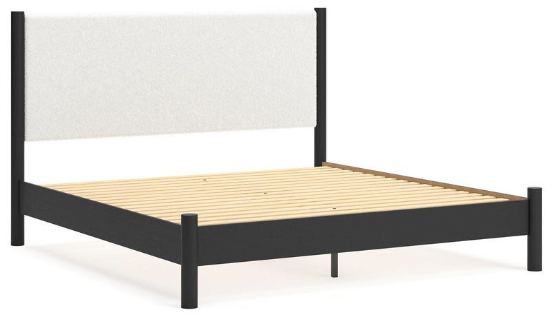 Ashley Furniture Cadmori upholstered bed with a padded headboard and sleek design, shown from an angled side view.