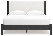 Ashley Furniture Cadmori upholstered bed with a padded headboard and neutral fabric, shown from a front angle.
