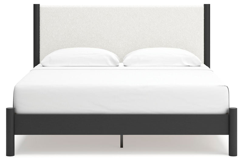Ashley Furniture Cadmori upholstered bed with a padded headboard and neutral fabric, shown from a front angle.