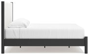 Ashley Furniture Cadmori upholstered bed with a plush, padded headboard and neutral fabric, shown in side view.