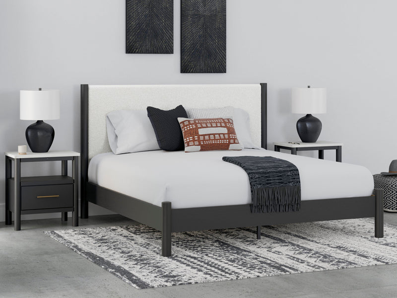 Ashley Furniture Cadmori upholstered bed with a plush fabric headboard and elegant design, shown in a modern bedroom setting.