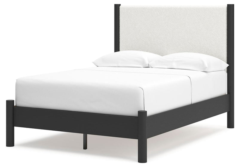 Ashley Furniture Cadmori upholstered bed with a padded headboard and soft fabric in a stylish bedroom setting.