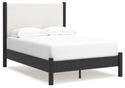 Ashley Furniture Cadmori upholstered bed with a plush headboard and elegant design, shown from an angled side view.