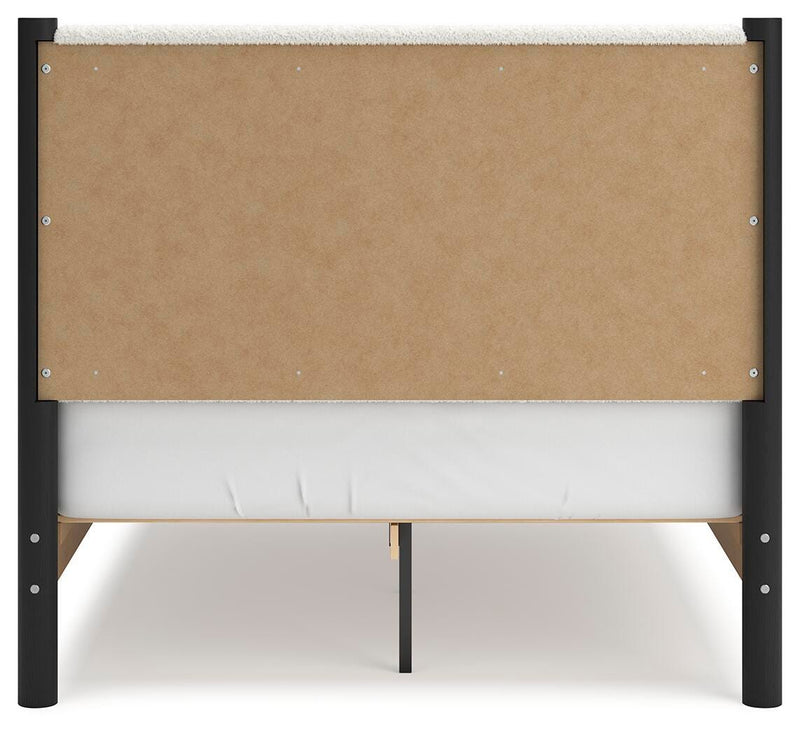 Ashley Furniture Cadmori upholstered bed with a padded headboard and sleek design, shown in a stylish bedroom setting.